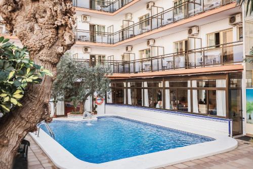 a swimming pool in front of a building at Hotel Camposol in Benidorm