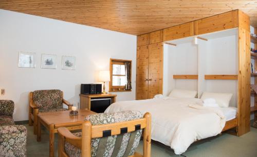 a bedroom with a bed and a table and chairs at Schweizerhof 604 mit Zugang zum Familienbad Lenzerheide in Lenzerheide