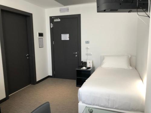 a bedroom with a white bed and a black door at Loto Business Hotel in Rome