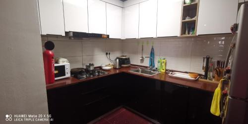 a kitchen with white cabinets and a counter top at 回家民宿 in Dubai