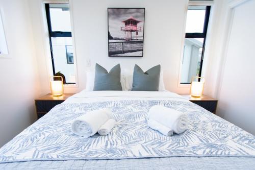 - une chambre avec un lit et 2 serviettes dans l'établissement Sunsoaked seaside 1 bedroom 1 bath, à Christchurch