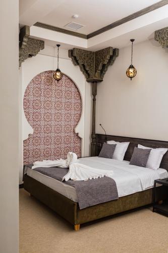 a bedroom with a large bed with a red headboard at Rasoda Hotel&Restaurant in Tashkent
