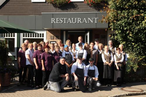 a group of people posing for a picture in front of a restaurant at Ringhotel Paulsen in Zeven