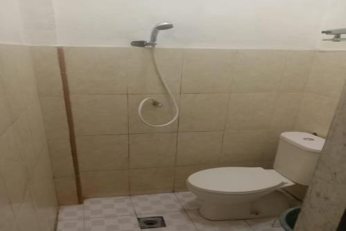 a bathroom with a toilet and a shower at OYO 92503 Penginapan & Villa Sirait in Parapat