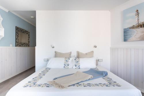 a bedroom with a white bed with a blanket on it at Monolocale a 50m dal lungomare di Las Americas in Arona