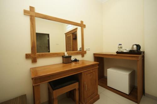 a bathroom with a wooden desk and a mirror at Swastika Bungalows in Sanur