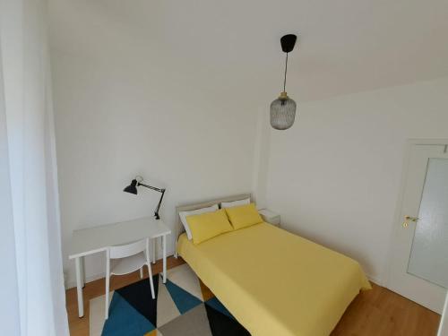 a small room with a yellow bed and a desk at San Paolo's Room in Milan