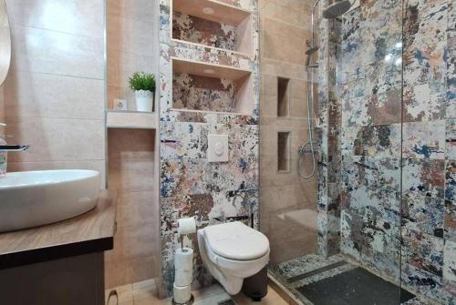 a bathroom with a toilet and a sink and a shower at Emerald Apartment Mamaia Nord in Năvodari