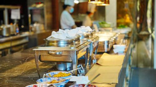 a buffet line with bowls of food in a restaurant at Crowne Plaza Hotel Lanzhou by IHG in Lanzhou