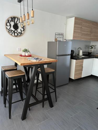 eine Küche mit einem Holztisch mit Stühlen und einem Kühlschrank in der Unterkunft Le cottage de L’héron 