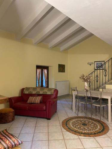 een woonkamer met een rode bank en een tafel bij LA CASA TRA GLI ULIVI in Spello