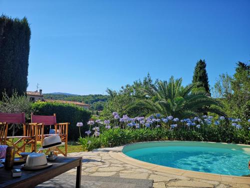 uma piscina num jardim com uma mesa e cadeiras em VILLA Sybel au charme provencal em Le Rouret