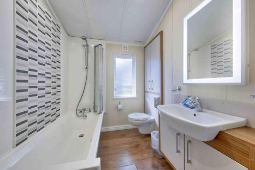 een witte badkamer met een wastafel en een toilet bij New Forest lodge - 194 NO PETS in Fordingbridge