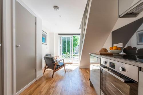 a kitchen with a table and a chair at The Studio, Rosebud. 5 minutes walk to beach. in Uny Lelant