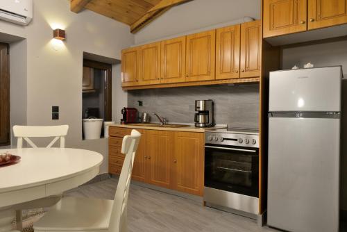 uma cozinha com armários de madeira e um frigorífico branco em PALIO HANI em Konitsa