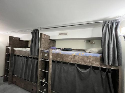 a room with two bunk beds and a mirror at Hostel VOYAGE in Batumi