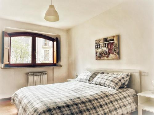 a bedroom with a bed with a plaid blanket at Le Masserie Case Vacanza in Villetta Barrea