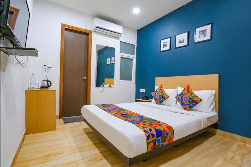 een slaapkamer met een groot bed met blauwe muren bij FabHotel F9 Peeragarhi in New Delhi
