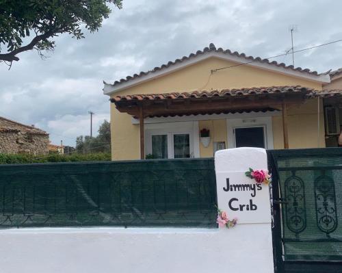 a house with a sign on a fence at Jimmy's Crib in Moudhros