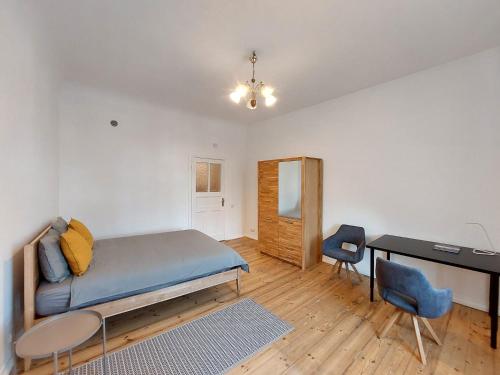 a bedroom with a bed and a desk and a table at Dainas 2-room Apartment - Arena Riga in Riga