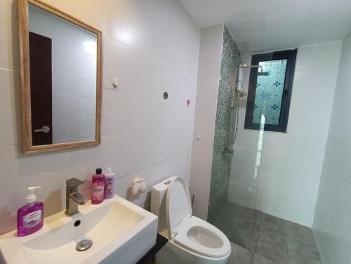 een badkamer met een wastafel, een toilet en een spiegel bij A.Foo Homestay 4.2 @ Vivacity Megamall Jazz Suite 4 in Kuching