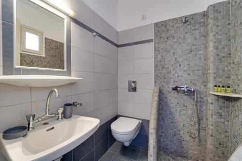 La salle de bains est pourvue de toilettes, d'un lavabo et d'une douche. dans l'établissement M.G. Hotel Studio & Apts, à Perissa