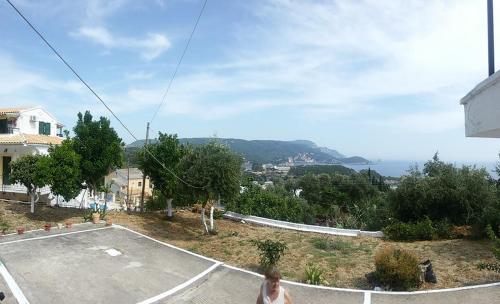 a woman walking down a street next to a parking lot at LITHERI-Studios&Apartment in Paleokastritsa