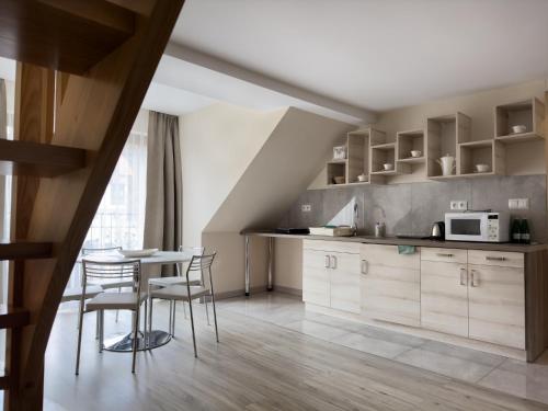 una cucina con mobili in legno, tavolo e sedie di Pensjonat Przy Deptaku w centrum Polanicy Zdrój a Polanica-Zdrój