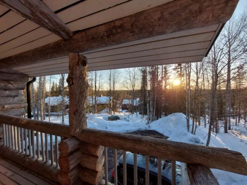 una ventana en una cabaña de madera con nieve en el suelo en Lomaruka, en Ruka