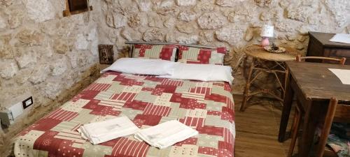 a bedroom with a bed in a stone wall at B&B Nonno Severino in Santo Stefano di Sessanio