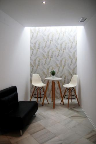 a dining room with a table and two chairs at Apartamentos GADIR CENTRO in Cádiz