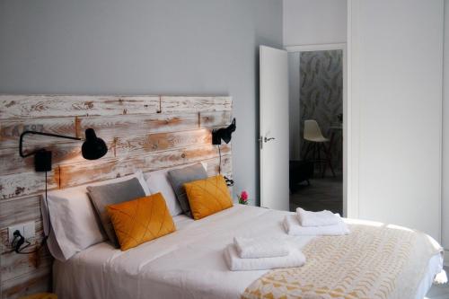 a bedroom with a large white bed with orange pillows at Apartamentos GADIR CENTRO in Cádiz