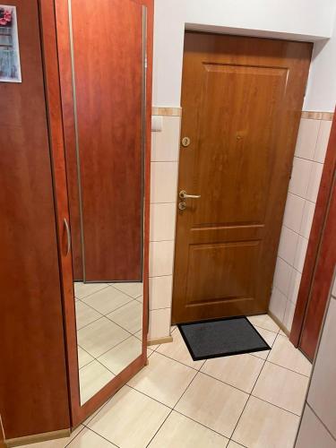 baño con puerta de madera y suelo de baldosa en MIESZKANIE, en Sianów