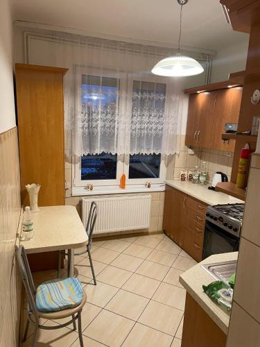 cocina con mesa, sillas y ventana en MIESZKANIE, en Sianów