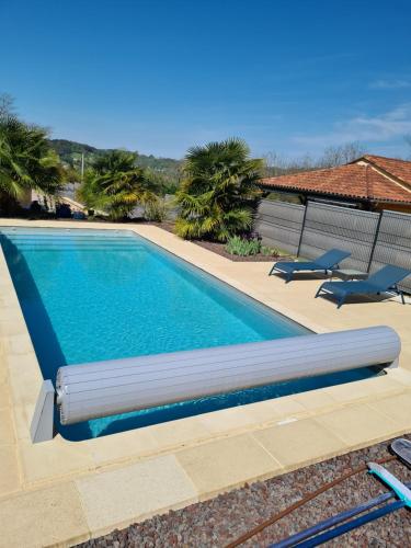 - une piscine avec 2 chaises en face d'une maison dans l'établissement Sarlat appartement, à Sarlat-la-Canéda
