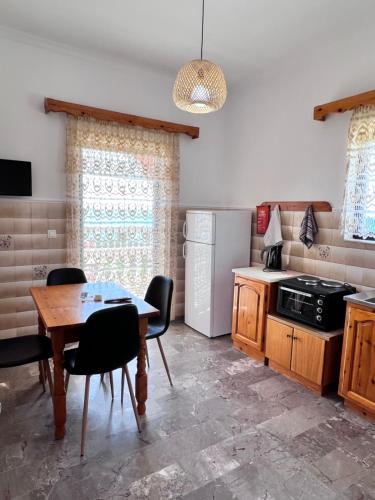 een keuken met een tafel en een koelkast bij Splish Splash Apartments in Arillas