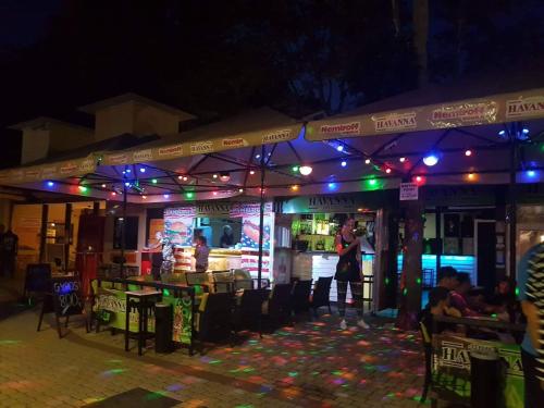 - un restaurant avec des lumières violettes et vertes la nuit dans l'établissement Syrah Wellness Apartman Siófok, à Siófok