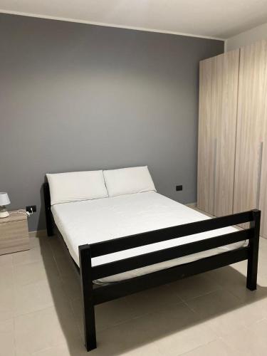 a bedroom with a bed with white sheets at Villa swamy in Bisceglie