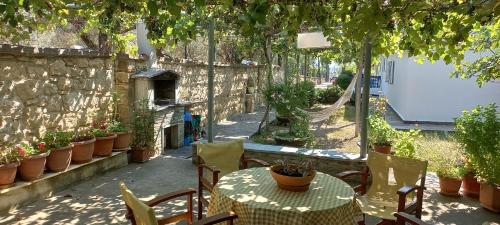un patio extérieur avec une table, des chaises et des plantes dans l'établissement PydnaRooms, à Skála Alykís
