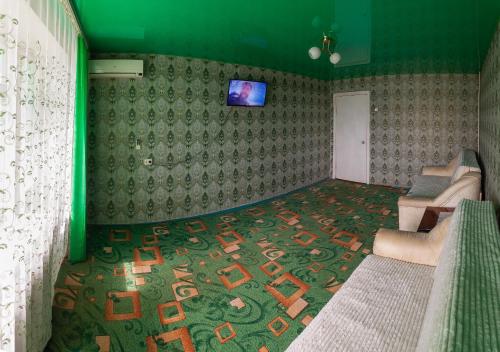 Habitación con sofá y TV en la pared. en Apartment Mira 35 en Krivói Rog