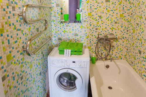 a bathroom with a washing machine and a bath tub at Apartment Mira 35 in Kryvyi Rih