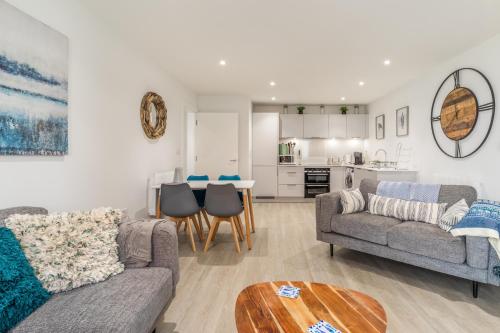 a living room with two couches and a table at 1 Putsborough - Luxury Apartment at Byron Woolacombe, only 4 minute walk to Woolacombe Beach! in Woolacombe