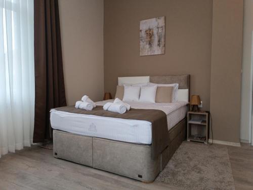a bedroom with a bed with two towels on it at Vila Bor in Bečej