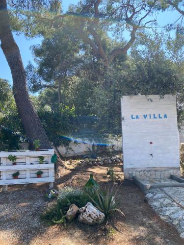 a sign that says la villa next to a tree at Appartamenti La Villa Peschici in Peschici