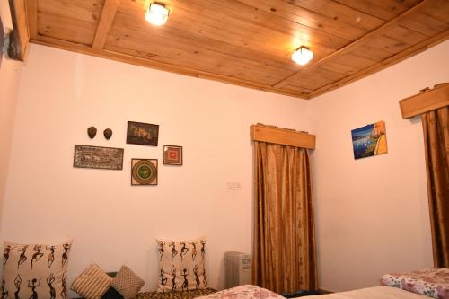 a bedroom with two beds and a wooden ceiling at The Shivdhaar Estate kud'Patnitop in Kūd
