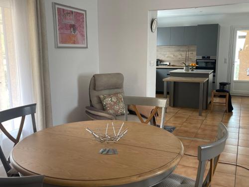 a dining room and kitchen with a table and chairs at Confortable villa de vacances entre Nîmes, le Pont du Gard, Uzès, Arles, Avignon in Marguerittes