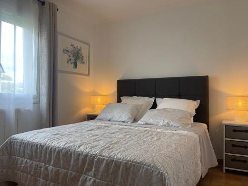 - une chambre dotée d'un grand lit avec des draps et des oreillers blancs dans l'établissement Confortable villa de vacances entre Nîmes, le Pont du Gard, Uzès, Arles, Avignon, à Marguerittes