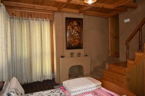 a living room with a fireplace in a house at The Shivdhaar Estate kud'Patnitop in Kūd