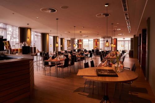 ein Restaurant mit Tischen und Stühlen in einem Zimmer in der Unterkunft Hotel Sportforum in Rostock