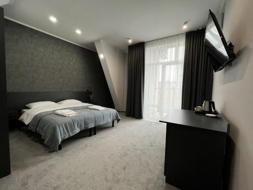 a bedroom with a bed and a flat screen tv at GOLDEN RING in Ternopilʼ